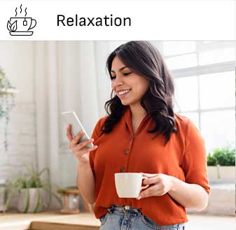 Lady enjoying a cup of tea while watching her phone